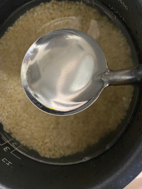 お米の水をすくいとるところ